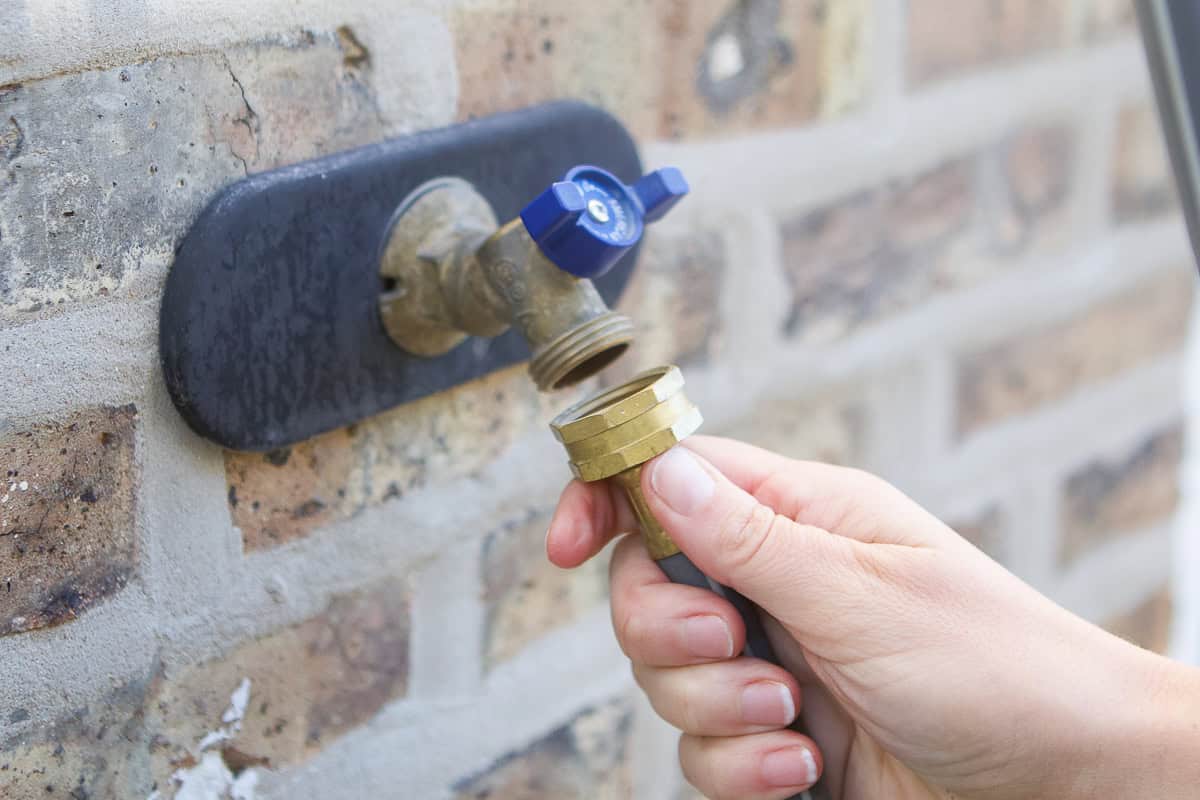 A person disconnecting a hose